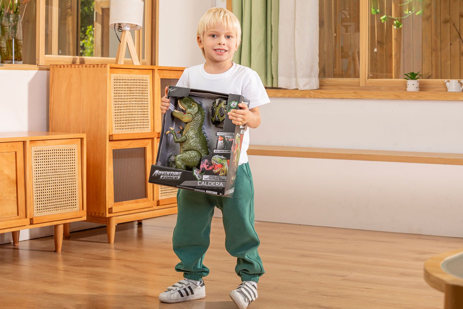 Child standing in a living room holding a boxed toy dinosaur set, highlighting professional product photography.