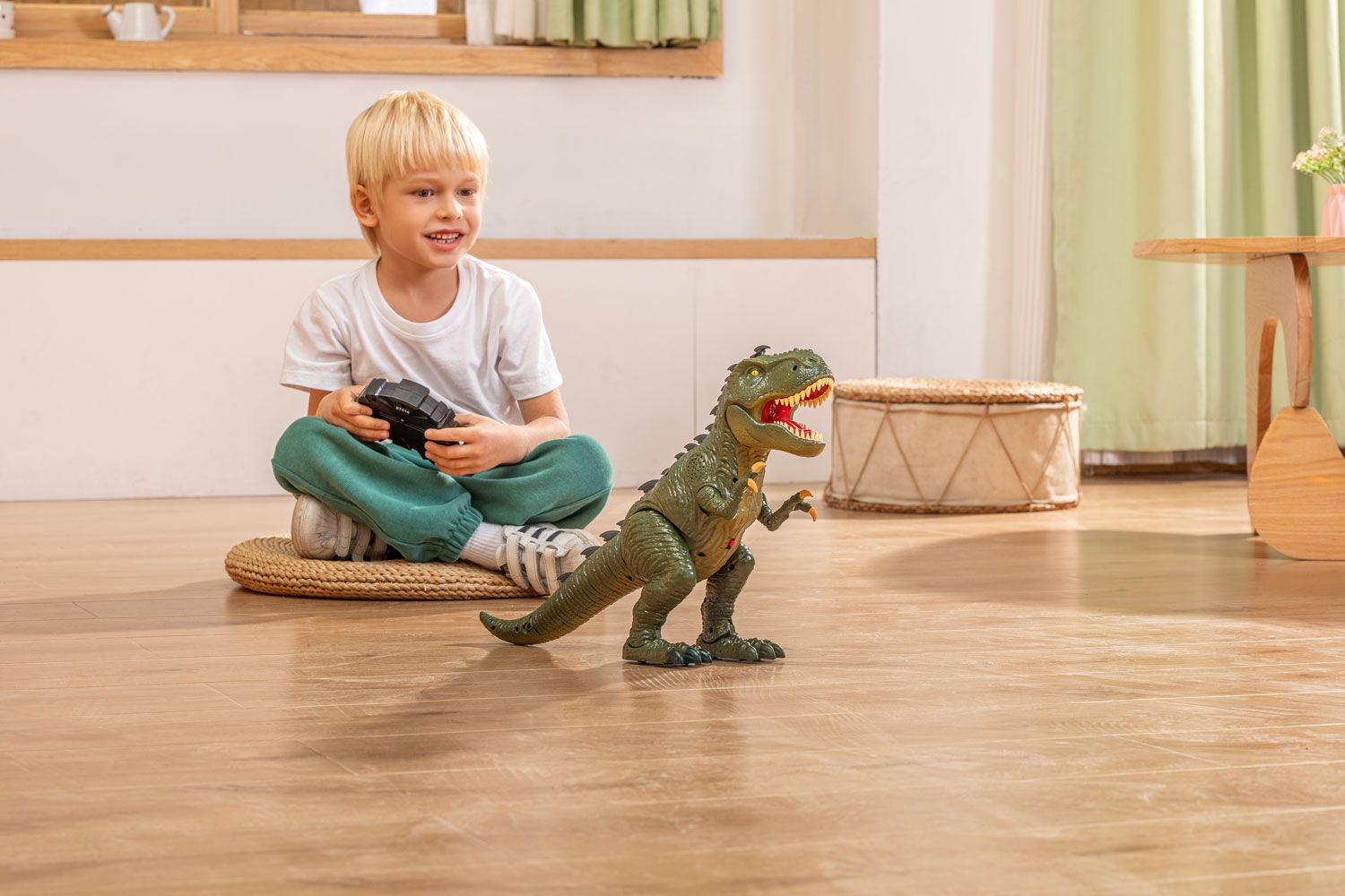 Smiling child seated indoors controlling a toy dinosaur with a remote, showcasing our studio's product photography expertise